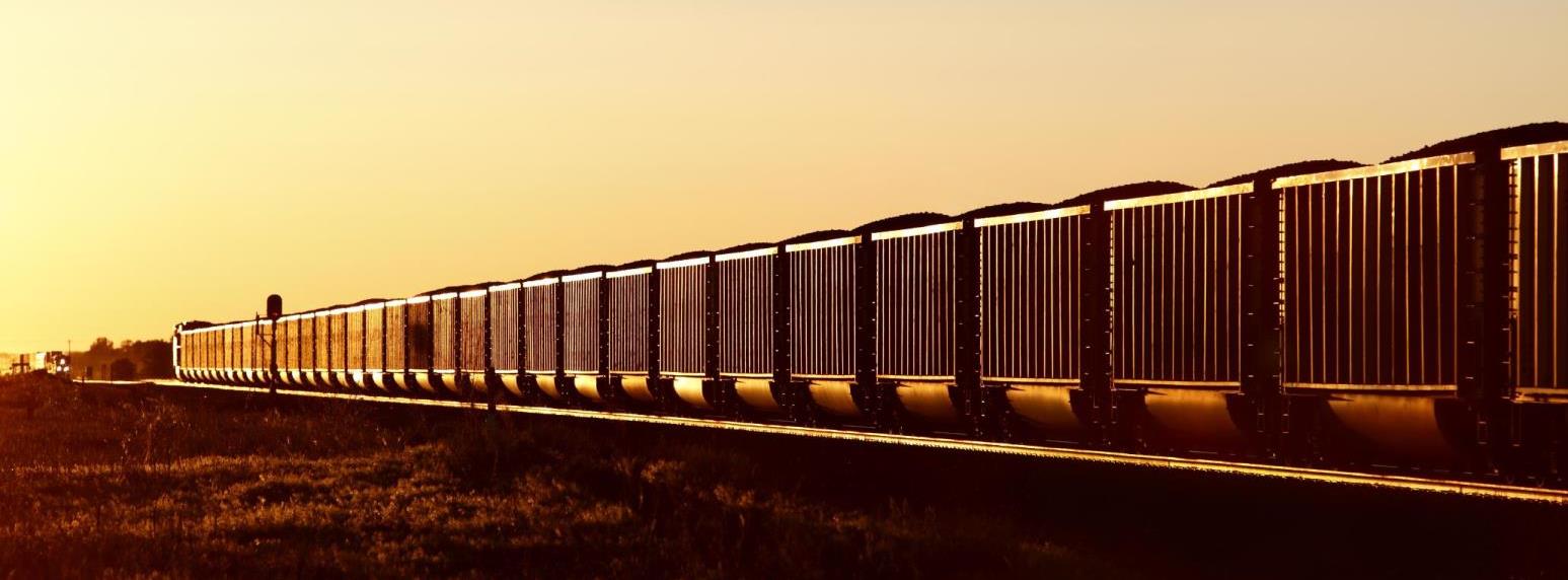 Side angle view of train carrying coal at sunset