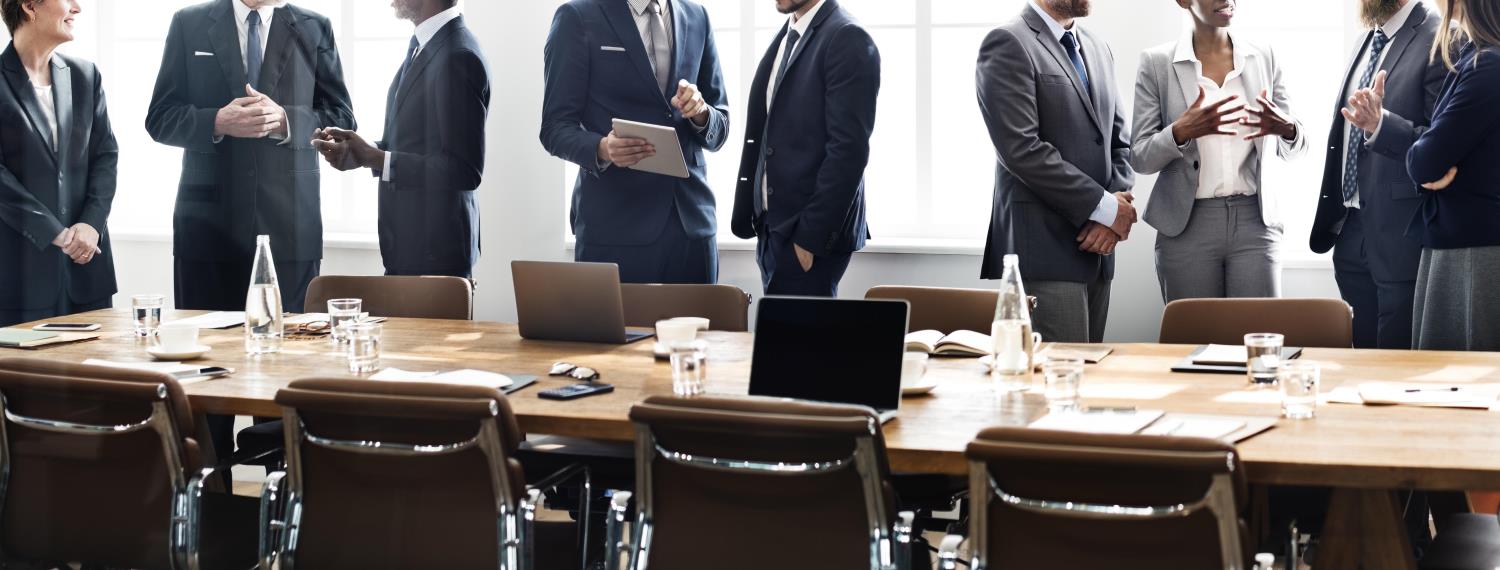 group of people in suits at board room table