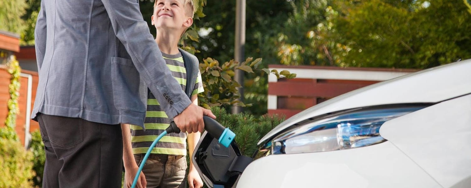 dad and son at ev charging station